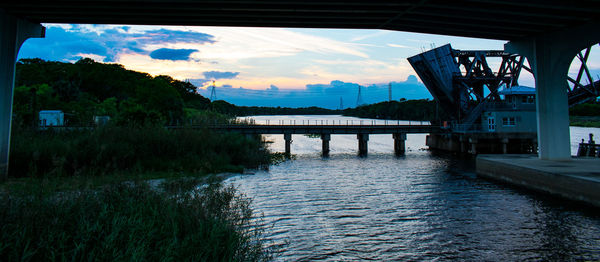 Bridge over river against sky during sunset