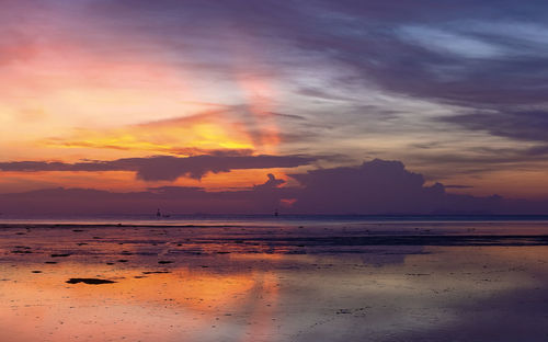 Scenic view of sea against dramatic sky during sunset