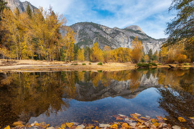 Reflection of trees in lake against mountains during autumn