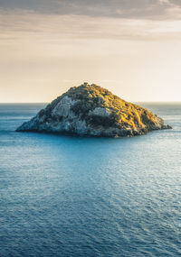 Scenic view of rock formation in sea against sky