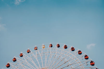 Low angle view of ferris wheel against blue sky