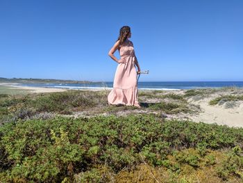 Woman standing on beach against clear sky