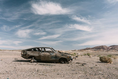 Abandoned truck on field against sky