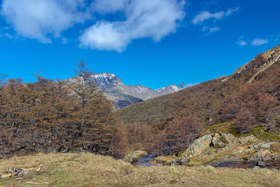 Scenic view of mountains against blue sky