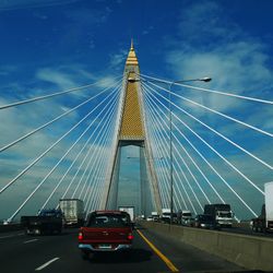 View of suspension bridge against cloudy sky