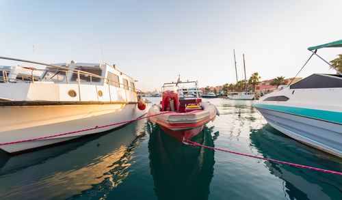 Boats moored in sea against clear sky