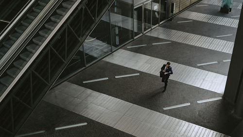 High angle view of businessman walking on footpath