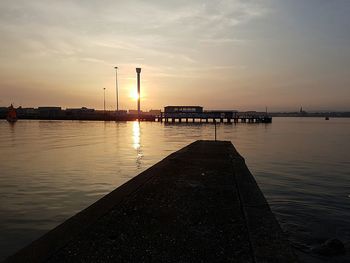 Pier on sea at sunset