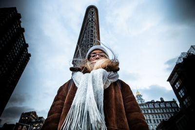 Low angle view of woman standing in city