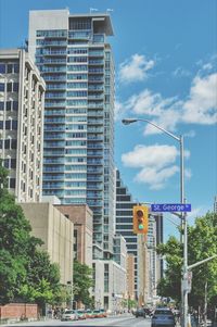 Buildings in city against cloudy sky