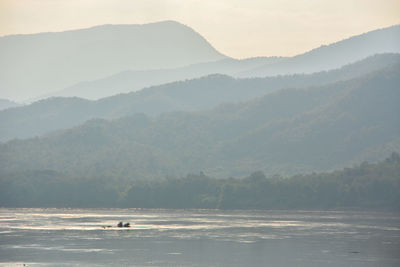 Scenic view of sea and mountains against sky