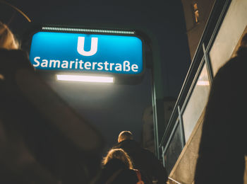 Rear view of people in illuminated bus at night