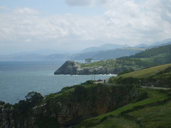 Scenic view of sea by mountains against sky