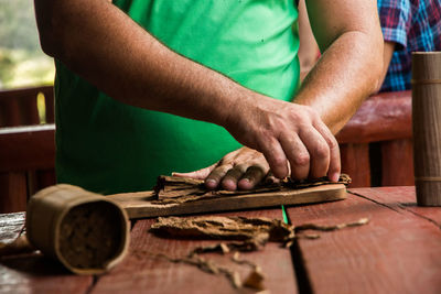 Close-up of man making cigar