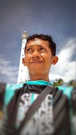 Low angle portrait of boy against sky