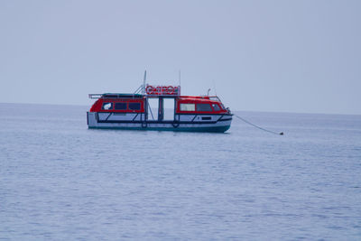 Boat sailing in sea against clear sky