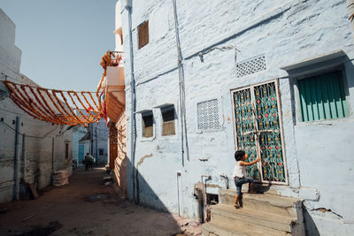 Man outside house on alley amidst buildings