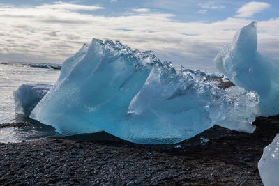 Frozen sea against sky during winter