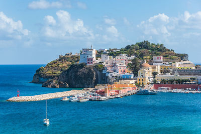 Scenic view of sea by buildings against sky