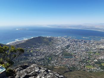 High angle view of buildings and sea against blue sky