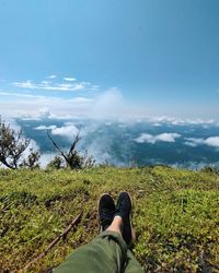 Low section of person legs on land against sky