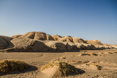 Scenic view of desert mountain forms like cake against clear blue sky