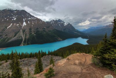 Lake with mountain in background against cloudy sky