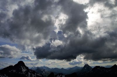 Low angle view of storm clouds over mountains