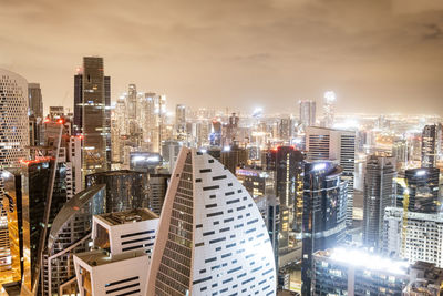 Illuminated cityscape against sky at night