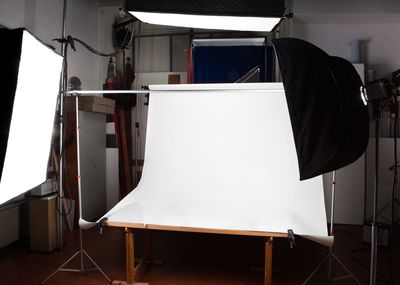Backdrop amidst illuminated lighting equipment at studio