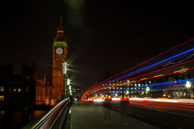 Light trails on westminster bridge by big ben in city at night