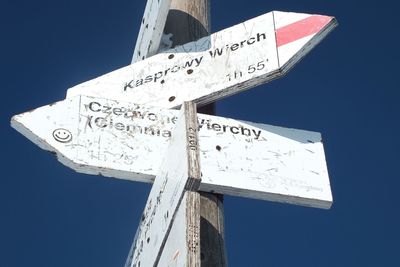 Low angle view of road sign against clear sky