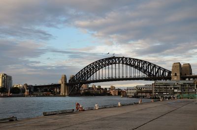 Bridge over river against cloudy sky