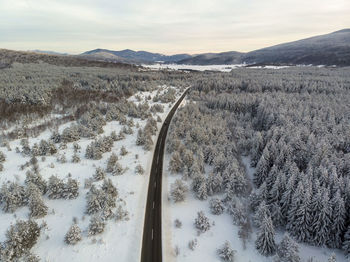 Scenic view of snow covered land against sky