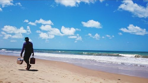 Full length of man walking on beach against sky