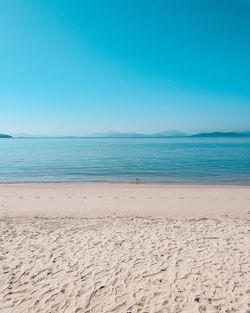 Scenic view of beach against clear blue sky