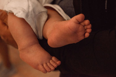 Small feet of a child in a dark orthodox church during the sacrament of baptism. 