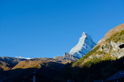 Scenic view of snowcapped mountains against clear blue sky