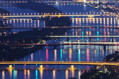 Illuminated bridge over river at night