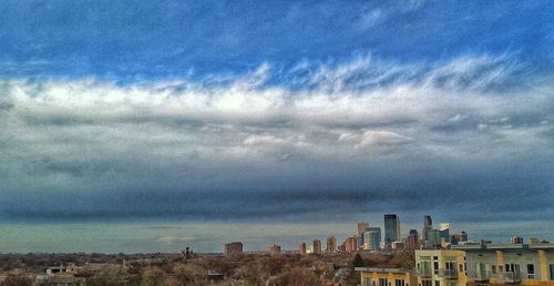 Buildings against cloudy sky