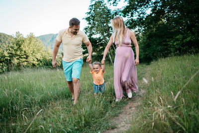 Happy family walking on field