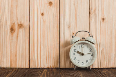 Close-up of clock on wooden wall