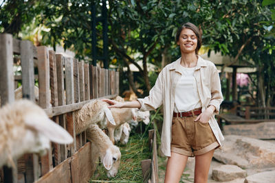 Portrait of young woman standing on field