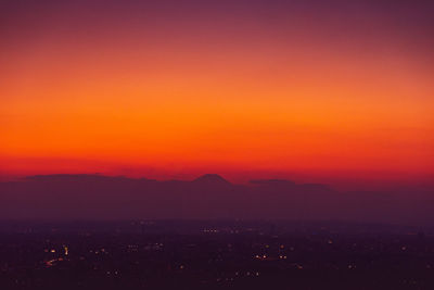 Scenic view of silhouette mountains against romantic sky at sunset