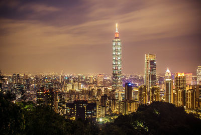 Illuminated buildings against sky at night