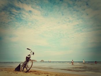 Bicycle on beach against sky