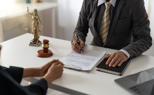 Midsection of businessman working at desk in office