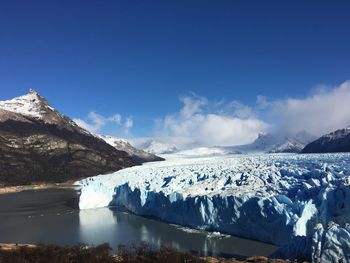 Scenic view of snowcapped mountains against blue sky