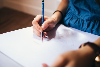 Midsection of woman drawing at home