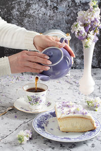 Still life with black tea and cheese cake, spring bouquet,delicate lilac flowers